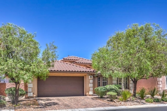 7998 Base Camp Ave, Las Vegas, NV 89178 - view of front of property with an attached garage, a tile roof, stucco siding, and decorative driveway