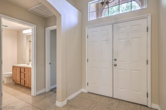 7998 Base Camp Ave, Las Vegas, NV 89178 - foyer featuring light tile patterned floors, a chandelier, and arched walkways
