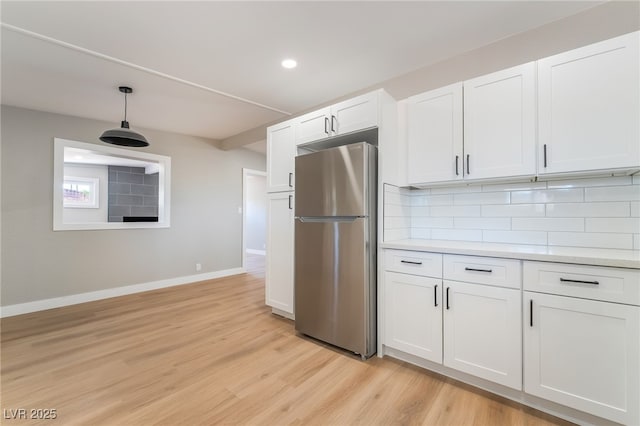 2749 Del Mar Pl, Las Vegas, NV 89169 - kitchen with freestanding refrigerator, backsplash, light wood-style flooring, white cabinets, and recessed lighting