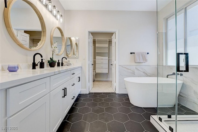 9632 Cherry Canyon Ave, Las Vegas, NV 89129 - bathroom with double vanity, a walk in closet, a freestanding tub, tile walls, and a stall shower