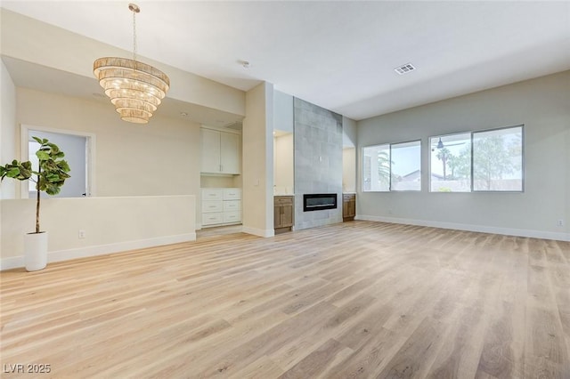 9632 Cherry Canyon Ave, Las Vegas, NV 89129 - unfurnished living room featuring light wood finished floors, a chandelier, and a fireplace