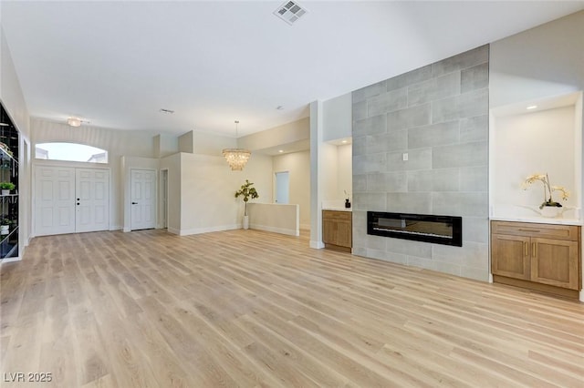 9632 Cherry Canyon Ave, Las Vegas, NV 89129 - unfurnished living room with light wood finished floors, a fireplace, and a chandelier