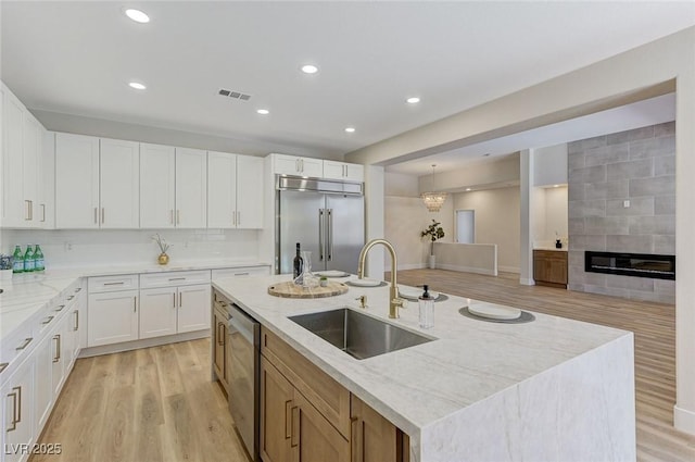 9632 Cherry Canyon Ave, Las Vegas, NV 89129 - kitchen featuring stainless steel appliances, light wood-style flooring, light stone counters, a kitchen island with sink, and recessed lighting