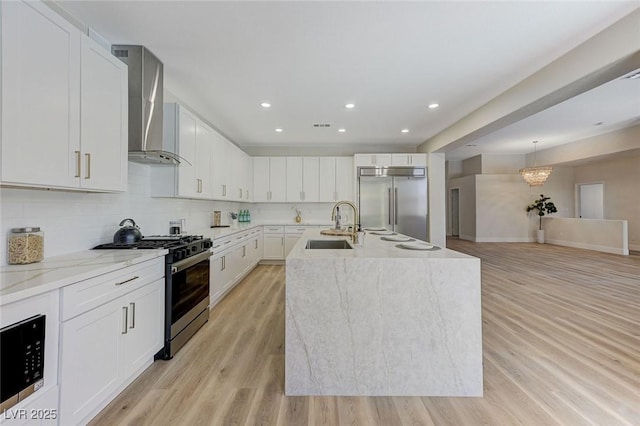 9632 Cherry Canyon Ave, Las Vegas, NV 89129 - kitchen featuring stainless steel appliances, wall chimney exhaust hood, a chandelier, white cabinetry, and light wood-style floors