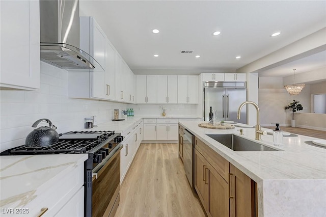 9632 Cherry Canyon Ave, Las Vegas, NV 89129 - kitchen with wall chimney exhaust hood, stainless steel appliances, light wood-type flooring, recessed lighting, and tasteful backsplash