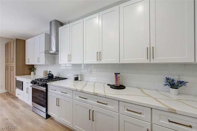 9632 Cherry Canyon Ave, Las Vegas, NV 89129 - kitchen featuring gas range, wall chimney exhaust hood, light wood-type flooring, white cabinets, and tasteful backsplash