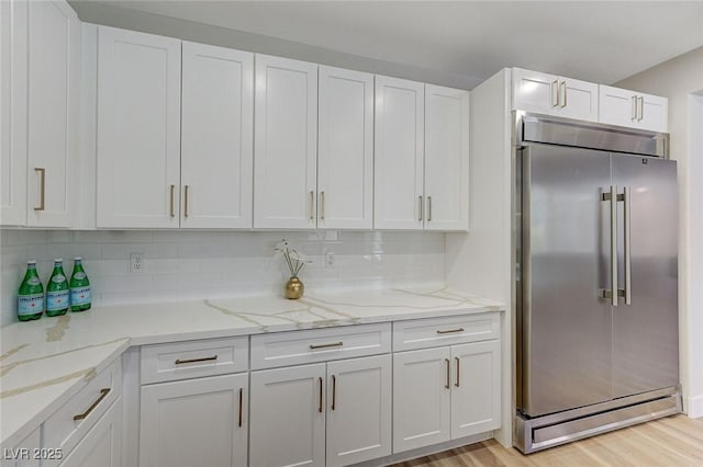 9632 Cherry Canyon Ave, Las Vegas, NV 89129 - kitchen with built in refrigerator, white cabinetry, light wood-type flooring, and decorative backsplash