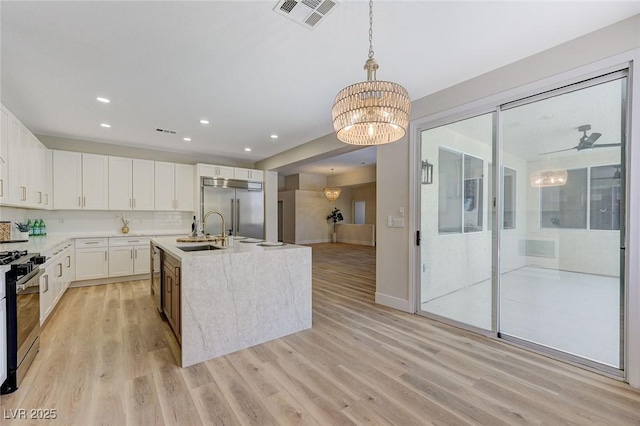 9632 Cherry Canyon Ave, Las Vegas, NV 89129 - kitchen featuring appliances with stainless steel finishes, a chandelier, light wood-style floors, white cabinetry, and recessed lighting