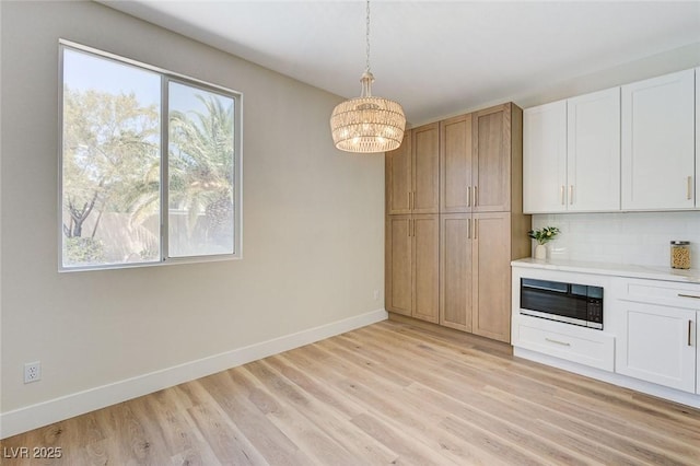 9632 Cherry Canyon Ave, Las Vegas, NV 89129 - kitchen featuring built in microwave, healthy amount of natural light, light wood-type flooring, and a chandelier