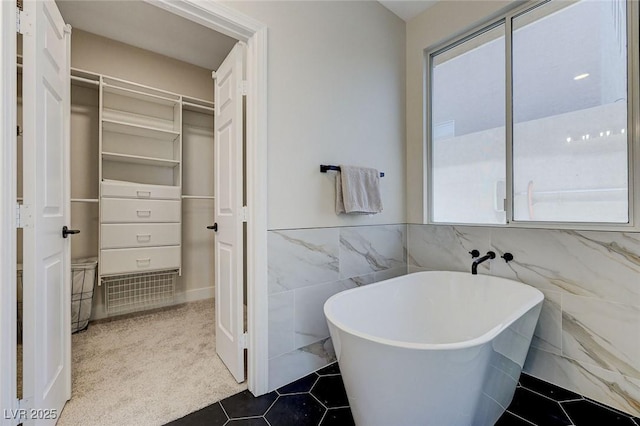 9632 Cherry Canyon Ave, Las Vegas, NV 89129 - full bath with a spacious closet, a freestanding bath, tile patterned flooring, wainscoting, and tile walls