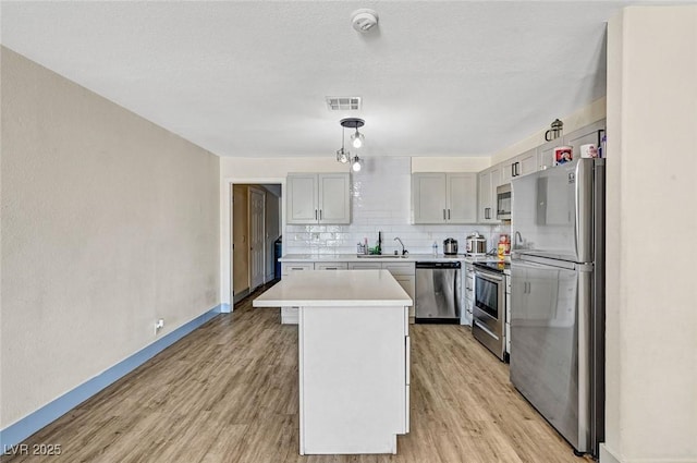 1804 David Ave, Las Vegas, NV 89101 - kitchen featuring appliances with stainless steel finishes, light wood-style flooring, light countertops, and decorative backsplash