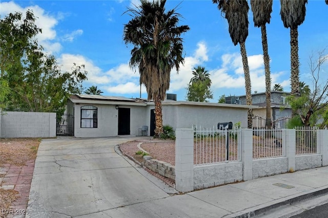 1804 David Ave, Las Vegas, NV 89101 - view of front of property featuring stucco siding, roof mounted solar panels, concrete driveway, a fenced front yard, and a gate
