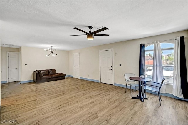 1804 David Ave, Las Vegas, NV 89101 - unfurnished living room featuring light wood-type flooring, a ceiling fan, a chandelier, and a textured ceiling
