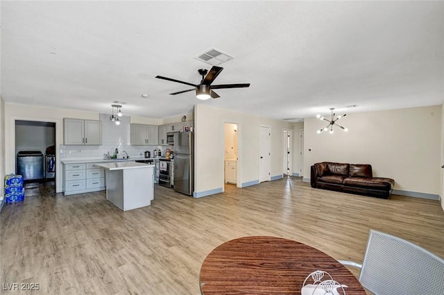 1804 David Ave, Las Vegas, NV 89101 - kitchen with gray cabinets, stainless steel appliances, light countertops, a chandelier, and a kitchen island