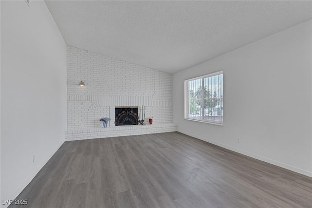 6808 Waterhen Cir, Las Vegas, NV 89108 - unfurnished living room featuring lofted ceiling, dark wood finished floors, a fireplace, and a textured ceiling