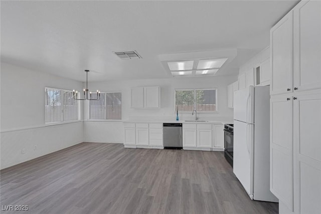 6808 Waterhen Cir, Las Vegas, NV 89108 - kitchen featuring freestanding refrigerator, dishwasher, white cabinets, and a chandelier
