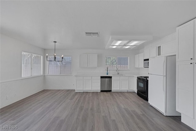 6808 Waterhen Cir, Las Vegas, NV 89108 - kitchen featuring appliances with stainless steel finishes, a chandelier, and white cabinetry