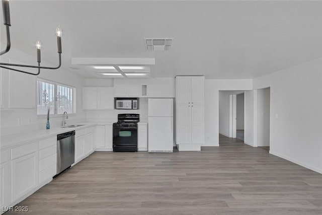 6808 Waterhen Cir, Las Vegas, NV 89108 - kitchen featuring appliances with stainless steel finishes, white cabinetry, light wood finished floors, and light countertops