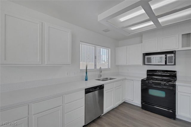 6808 Waterhen Cir, Las Vegas, NV 89108 - kitchen featuring stainless steel appliances, white cabinetry, light wood-type flooring, and light countertops