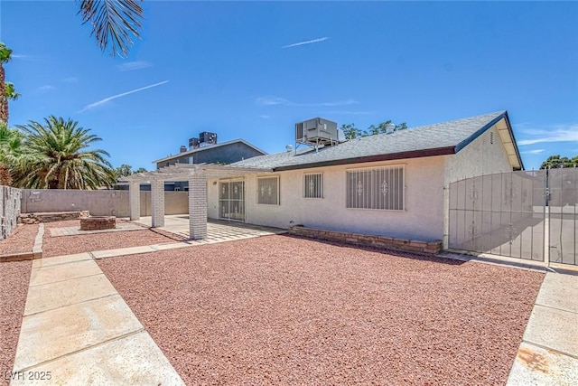 6808 Waterhen Cir, Las Vegas, NV 89108 - rear view of house with a fire pit, stucco siding, a patio area, and a gate