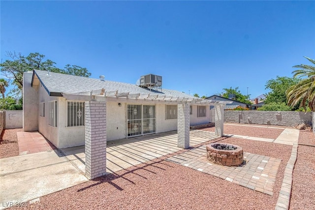 6808 Waterhen Cir, Las Vegas, NV 89108 - back of property featuring a pergola, a fire pit, a patio, stucco siding, and roof with shingles