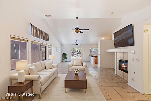 4043 Lilac Creek Ct, Las Vegas, NV 89122 - living room with vaulted ceiling, light tile patterned floors, ceiling fan, and a tile fireplace