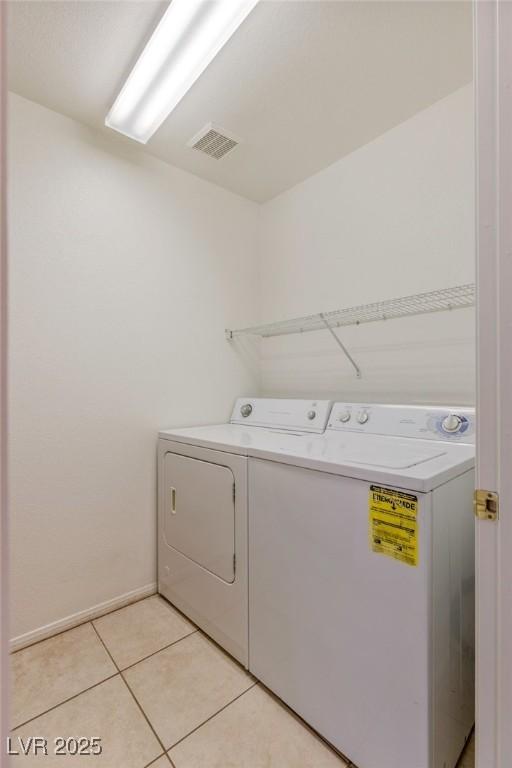 4043 Lilac Creek Ct, Las Vegas, NV 89122 - laundry area with washing machine and clothes dryer and light tile patterned floors