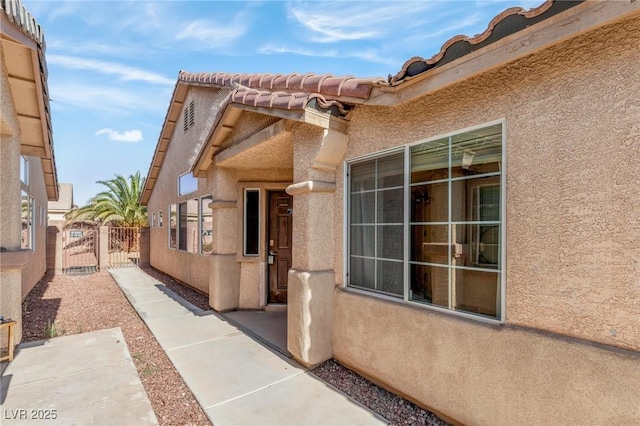 4043 Lilac Creek Ct, Las Vegas, NV 89122 - view of exterior entry featuring a gate, stucco siding, and a tile roof