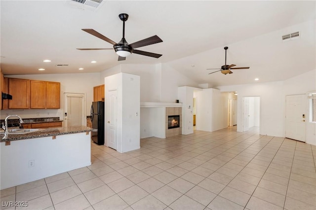 4043 Lilac Creek Ct, Las Vegas, NV 89122 - kitchen with vaulted ceiling, freestanding refrigerator, a ceiling fan, open floor plan, and a kitchen breakfast bar