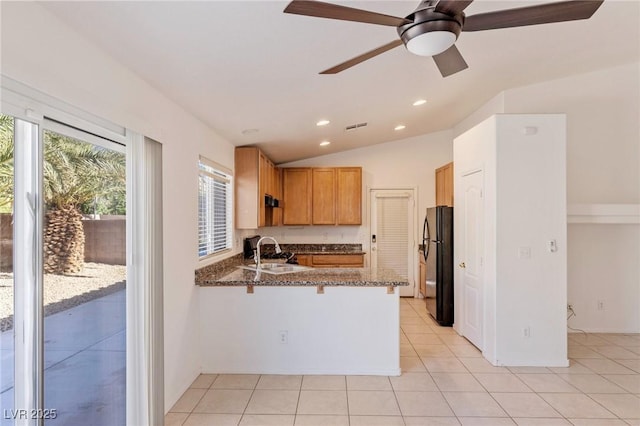 4043 Lilac Creek Ct, Las Vegas, NV 89122 - kitchen with freestanding refrigerator, a peninsula, healthy amount of natural light, dark stone countertops, and recessed lighting