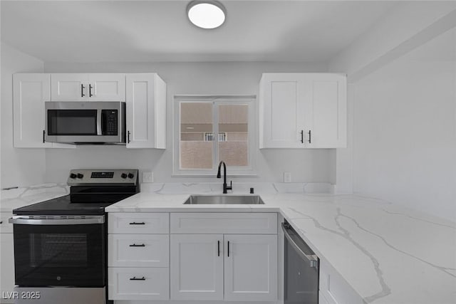 2005 Jansen Ave, Las Vegas, NV 89101 - kitchen featuring stainless steel appliances, white cabinets, and light stone countertops