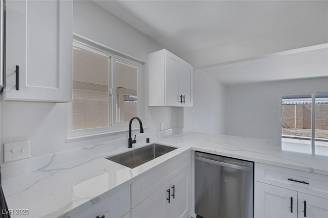 2005 Jansen Ave, Las Vegas, NV 89101 - kitchen with stainless steel dishwasher, white cabinets, and light stone countertops