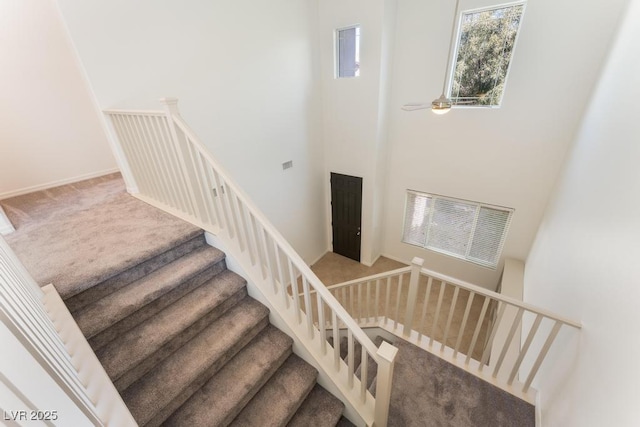 5735 Oak Bend Dr, Las Vegas, NV 89135 - staircase with carpet flooring, a high ceiling, and ceiling fan