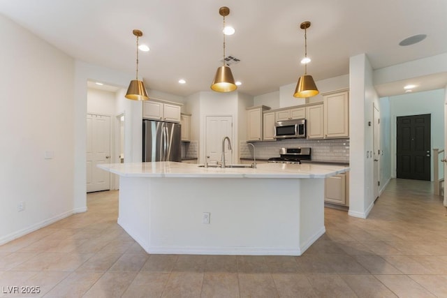 5735 Oak Bend Dr, Las Vegas, NV 89135 - kitchen with appliances with stainless steel finishes, tasteful backsplash, a center island with sink, light tile patterned floors, and cream cabinets
