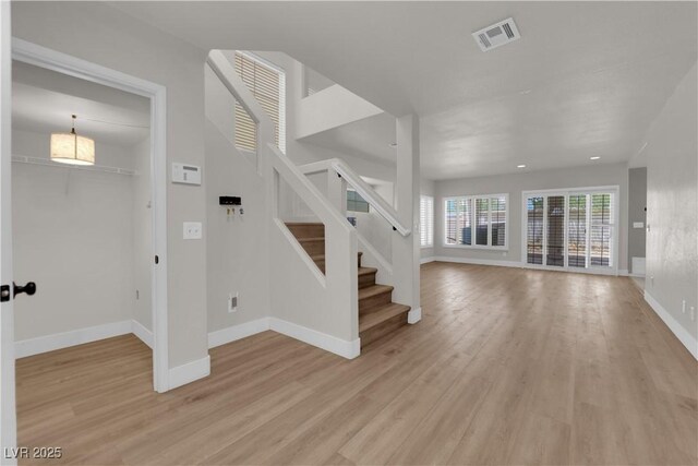 638 Ribbon Grass Ave, Las Vegas, NV 89183 - unfurnished living room with light wood-style flooring and stairs
