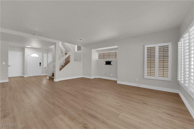 638 Ribbon Grass Ave, Las Vegas, NV 89183 - unfurnished living room with stairway, light wood-style flooring, and plenty of natural light