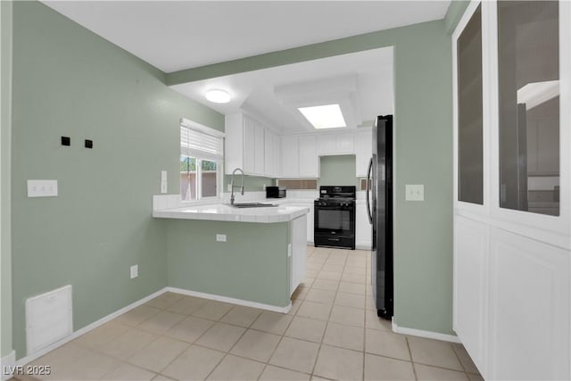 638 Ribbon Grass Ave, Las Vegas, NV 89183 - kitchen featuring stove, tile counters, white cabinetry, freestanding refrigerator, and light tile patterned floors