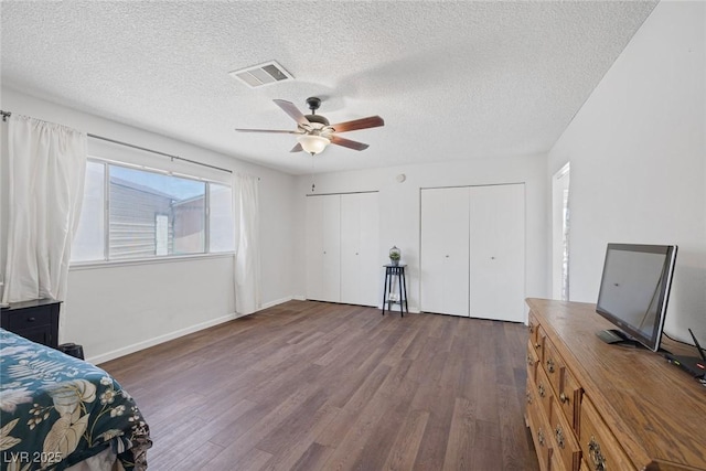 4458 El Quinta Ct, Las Vegas, NV 89121 - bedroom featuring wood finished floors, two closets, a textured ceiling, and a ceiling fan