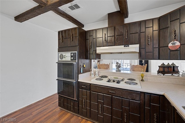 4458 El Quinta Ct, Las Vegas, NV 89121 - kitchen with white stovetop, beamed ceiling, under cabinet range hood, dark brown cabinetry, and dark wood finished floors