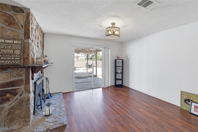 4458 El Quinta Ct, Las Vegas, NV 89121 - unfurnished living room with wood finished floors, a chandelier, a textured ceiling, and a large fireplace
