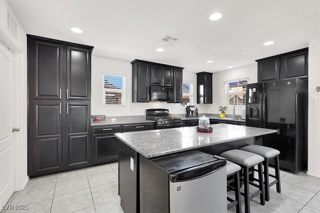 8949 Merry Mullion Ct, Las Vegas, NV 89149 - kitchen with black appliances, light tile patterned floors, a kitchen island, light stone countertops, and recessed lighting