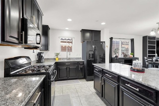8949 Merry Mullion Ct, Las Vegas, NV 89149 - kitchen featuring black appliances, dark cabinets, light stone countertops, light tile patterned floors, and recessed lighting