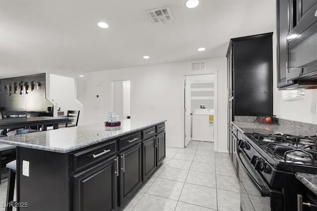 8949 Merry Mullion Ct, Las Vegas, NV 89149 - kitchen featuring dark cabinets, black appliances, recessed lighting, a center island, and light stone counters