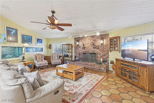 55 Siddall Ave, Las Vegas, NV 89183 - living area featuring a ceiling fan, track lighting, a fireplace, wooden walls, and light tile patterned floors
