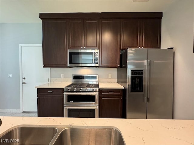 248 Crystal Rose Ct, Las Vegas, NV 89106 - kitchen featuring stainless steel appliances, dark brown cabinetry, and light stone countertops