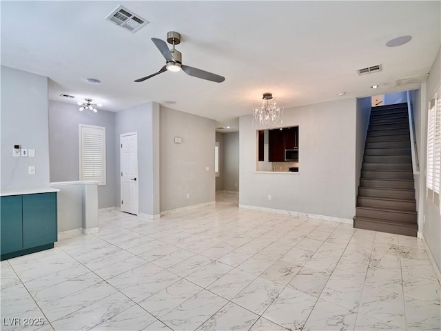 248 Crystal Rose Ct, Las Vegas, NV 89106 - unfurnished living room with stairs, a chandelier, ceiling fan, and light marble finish flooring