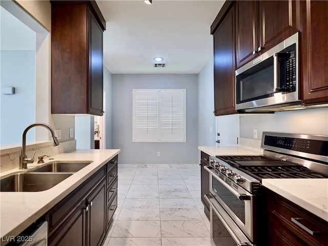 248 Crystal Rose Ct, Las Vegas, NV 89106 - kitchen with appliances with stainless steel finishes, light marble finish floors, dark brown cabinetry, and light stone counters