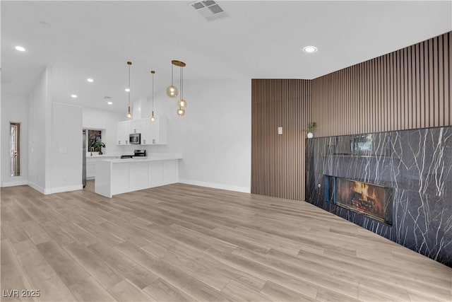 9412 Mount Cherie Ave Unit 102, Las Vegas, NV 89129 - unfurnished living room featuring light wood-style floors, recessed lighting, and a fireplace