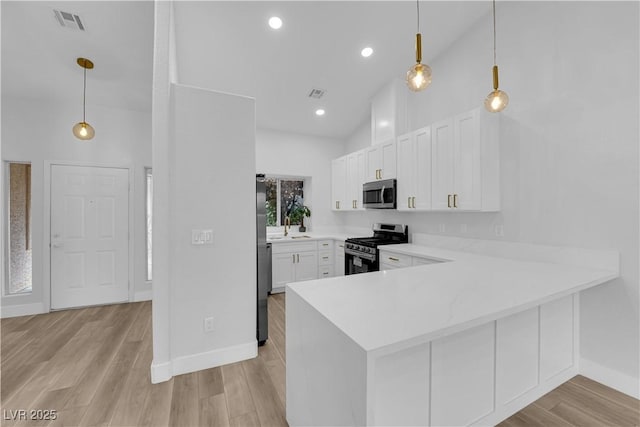9412 Mount Cherie Ave Unit 102, Las Vegas, NV 89129 - kitchen featuring appliances with stainless steel finishes, white cabinets, light wood finished floors, light countertops, and high vaulted ceiling