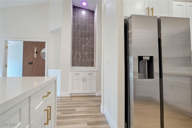9412 Mount Cherie Ave Unit 102, Las Vegas, NV 89129 - kitchen with stainless steel refrigerator with ice dispenser, white cabinets, light countertops, and light wood-style floors